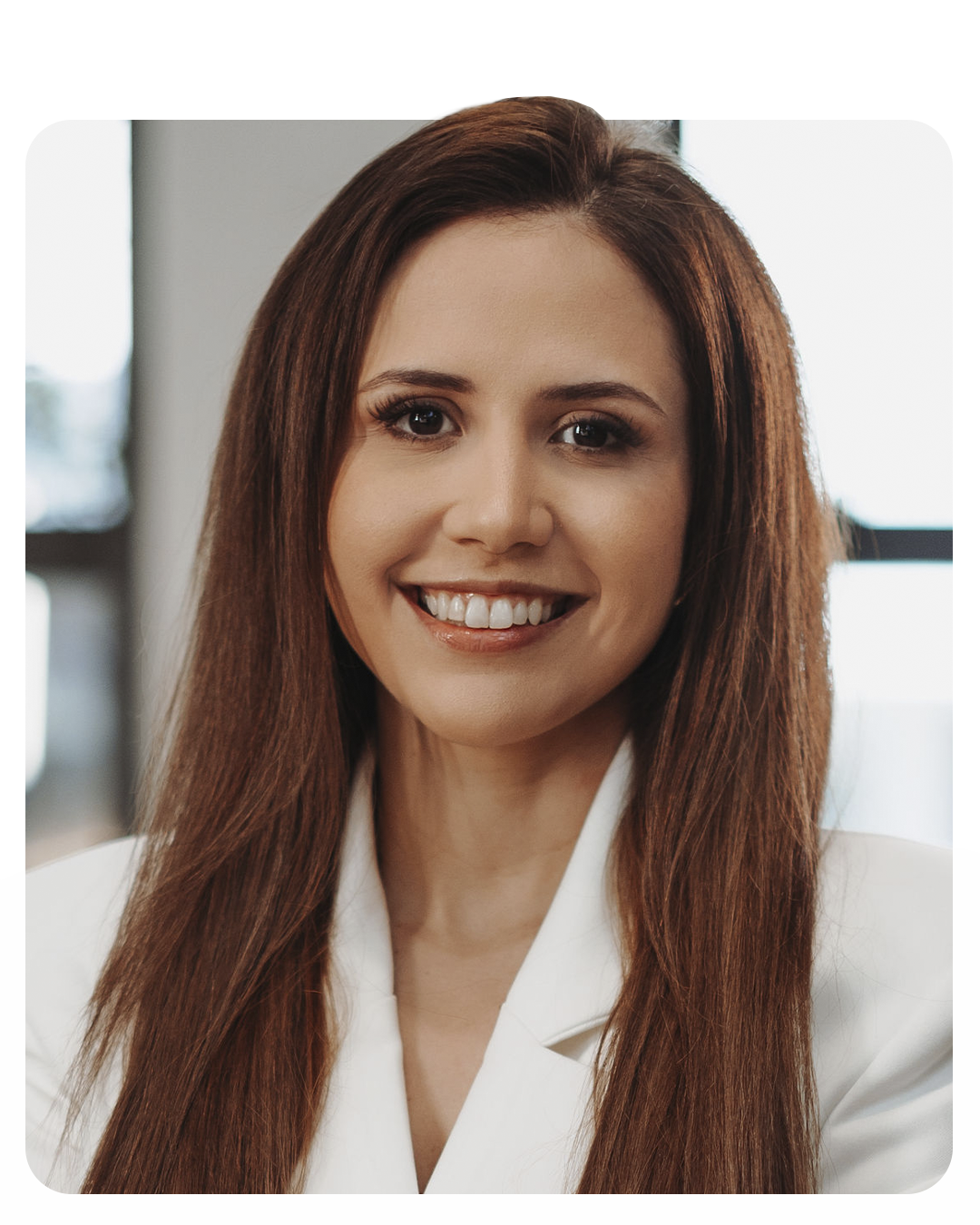 Retrato da Dra. Daniella Andretta sorrindo, de jaleco branco