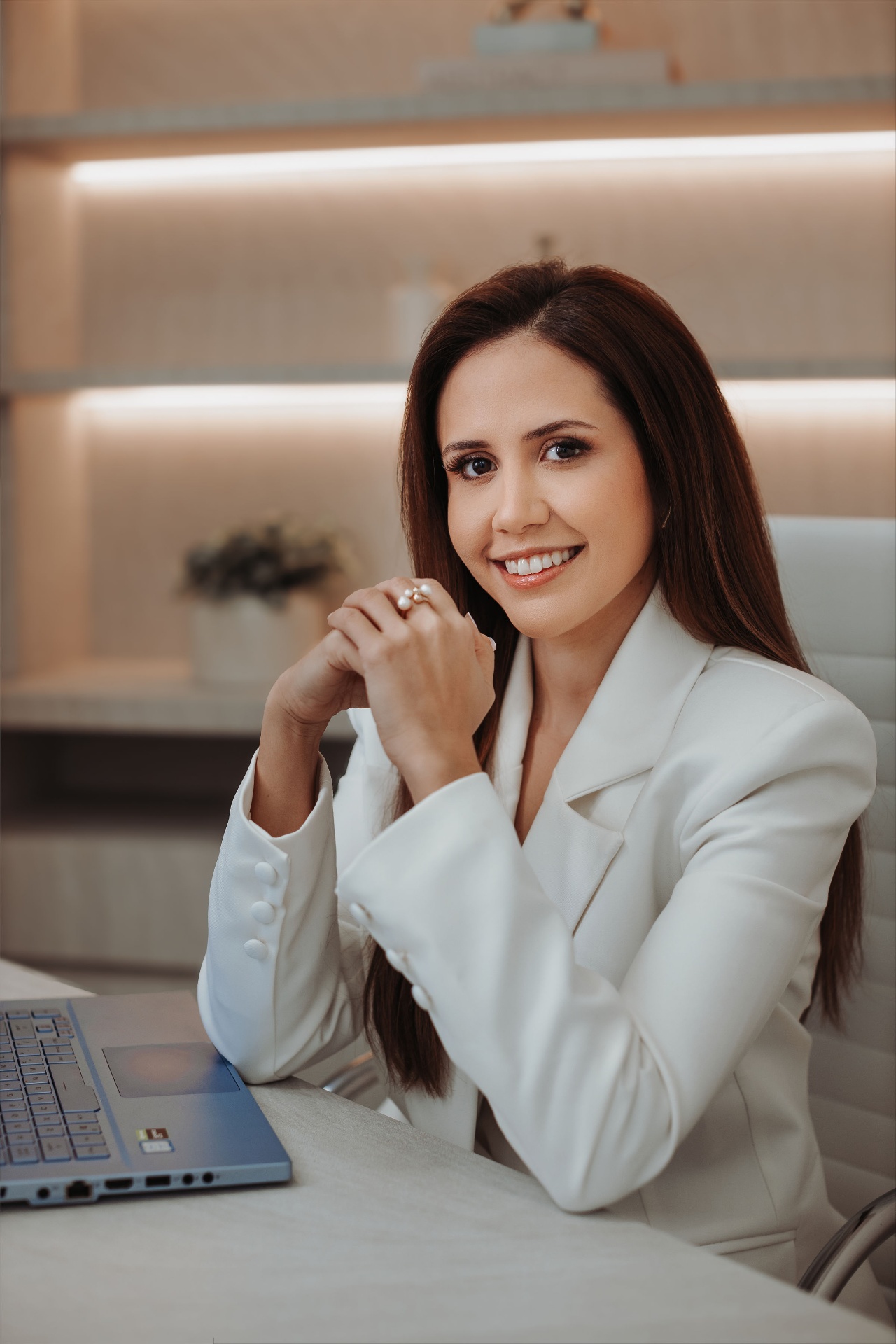 Dra. Daniella Andretta em atendimento, ao lado do notebook